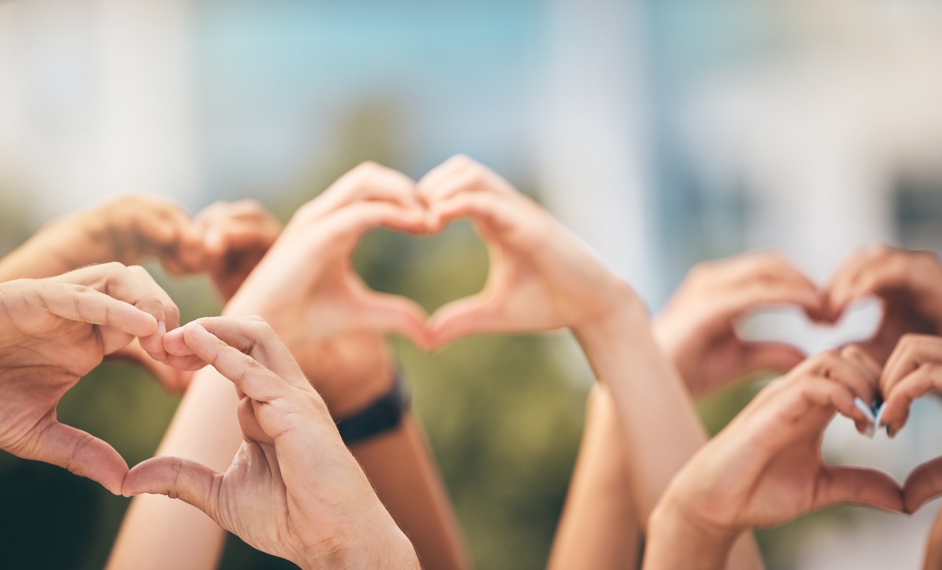 Crowd, hands and heart sign with group of people, community and friends with emoji for care, freedom and health outdoor. Fans, concert and support of men and women on solidarity for charity thank you